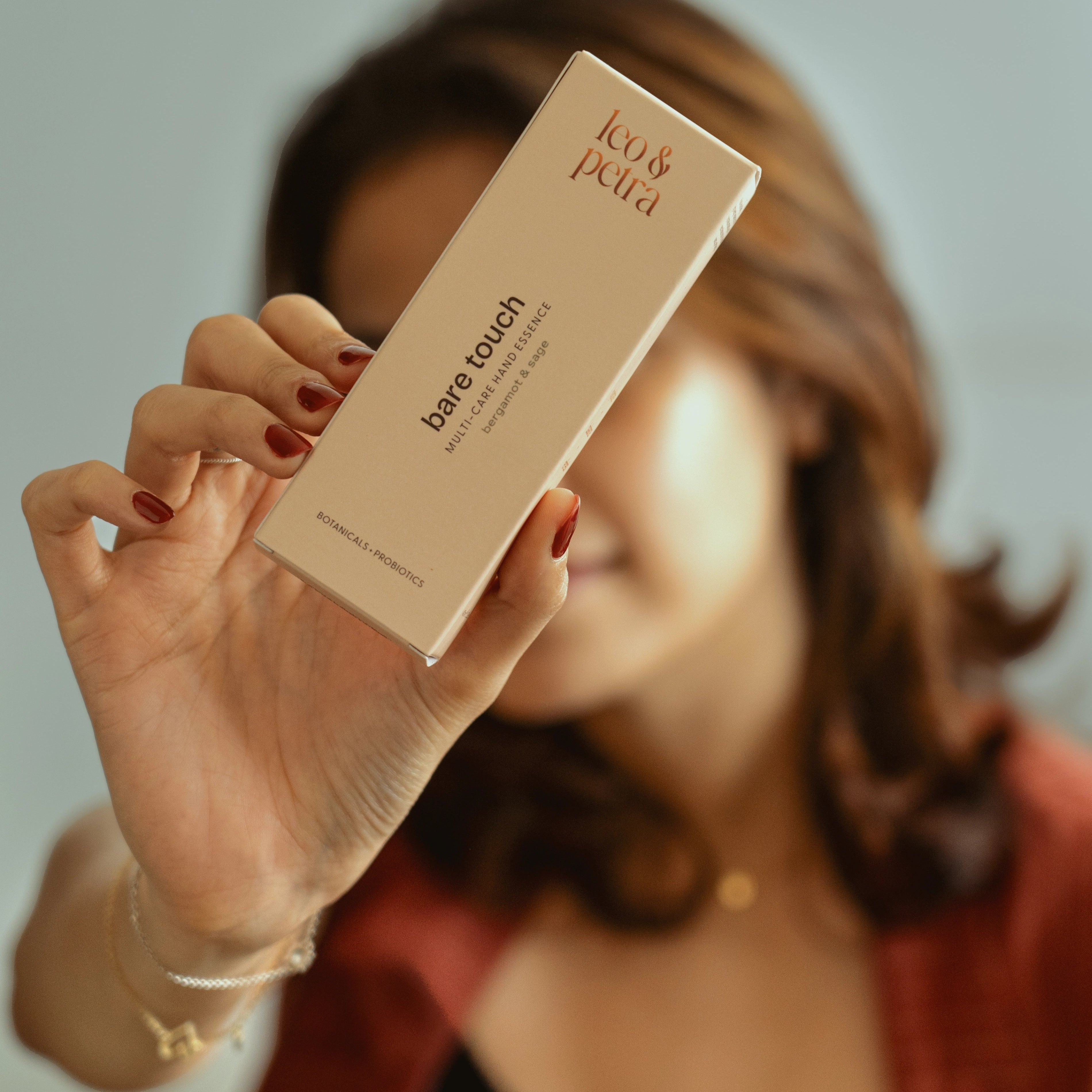 Person holding a product box with 'leo & petra' branding against a neutral background